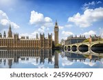 Summer view of the Westminster Bridge and Palace with Big Ben clocktower in London, England, with sun, clouds and reflections in the river Thames