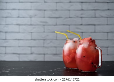Summer watermelon cocktail with ice and mint leaves. Cold refreshing organic soft drink on light gray background with copy space, watermelon fresh fresh juice, vegetarian drinks 