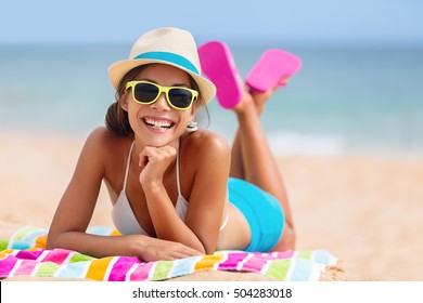 Summer Woman Relaxing In Hipster Beach Hat And Colorful Sunglasses. Funky Happy Girl Having Fun During Travel Holidays Vacation. Young Trendy Cool Hipster Woman In Bikini Lying In The Sand.