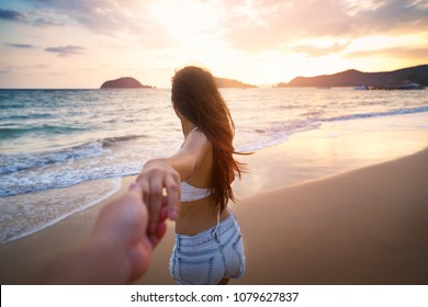 Summer woman vacations concept, Couple holding hands and walking on beach in sunset at Koh Mak, Thailand, Asia woman with white bikini and shorts jeans