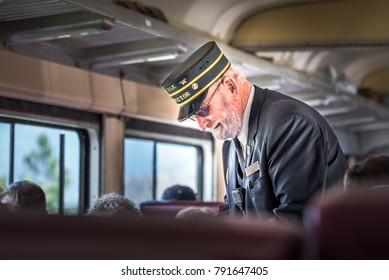 Summerland, British Columbia/Canada - May 14, 2017: the conductor takes tickets from passengers on the Kettle Valley Steam Railway, a popular tourist attraction in the Okanagan.