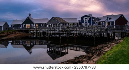 Summerside Harbour Sunset Seascape with rustic cape style houses and stores, and water reflections at twilight hour in Gulf of St Lawrence, Prince Edward Island, Canada