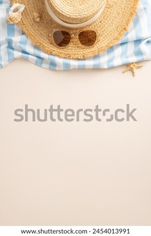 Summertime essentials from top view. Sun hat, shades, beach blanket, seashells on sandy beige. Ideal for promotions or captions