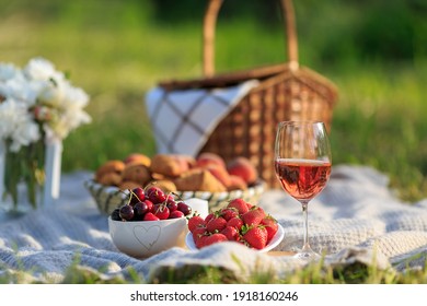 Summertime Healthy Picnic On Nature Background At Sunny Day. Close Up Basket Fruits Strawberries, Cherries, Glass Of Red Wine, On Green Grass In Garden. Summer Weekend Outdoor. Beautiful Still Life