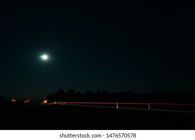 Summertime Night Rural Adventure From Middle Of Nowhere With Car Trails And The Moon Above