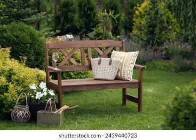 summertime relax in cottage garden. Wooden bench with pillow, lantern and petunia in flowerpot.  - Powered by Shutterstock