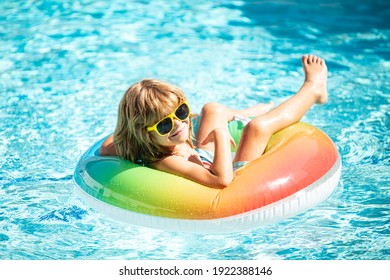 Summertime Vacation. Summer Kids Weekend. Funny Boy In Swiming Pool On Inflatable Rubber Circle At Aquapark