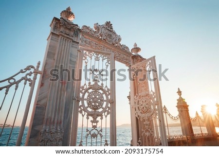 Sumptuous white gate towards the blue sea and sky. The Bosphorus through the open gate of Dolmabahce palace