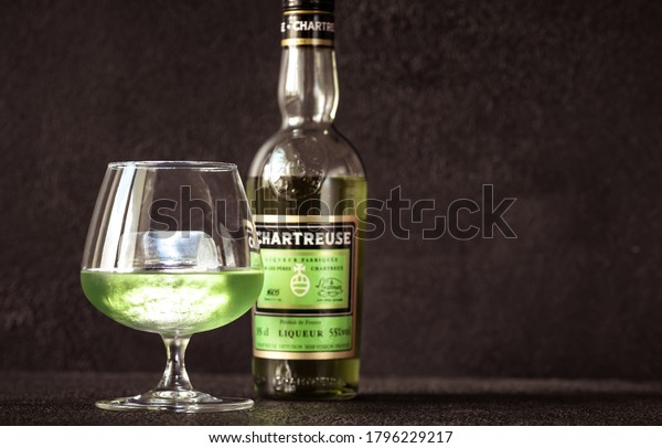 SUMY, UKRAINE - AUG 13: Glass of Chartreuse on\
the rocks on August 13, 2020. Chartreuse is French liqueur made\
from herbs in green\
version
