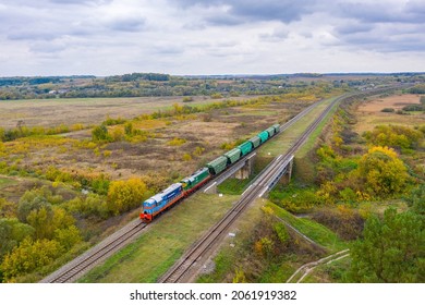 Sumy, Ukraine - Autumn 2021: Two powerful diesel locomotives pull a train from wagons loaded with grain and corn to the seaport.  Railway transportation of grain.  Ukrainian railway.  View from above.