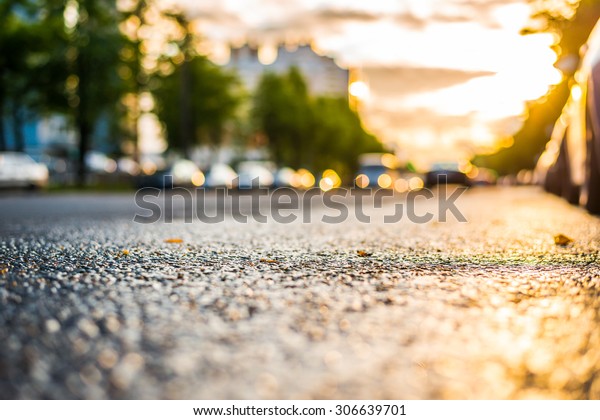 Sun after the rain in the city,\
headlights of the approaching cars, view from the road\
level