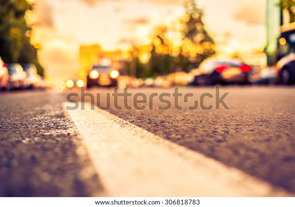 Sun after the rain in the city, view of the\
approaching car with the level dividing line. Image in the\
yellow-purple toning
