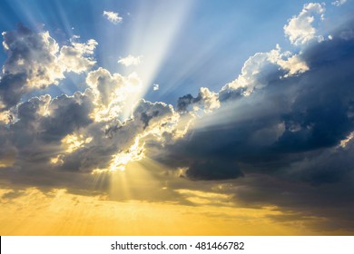 Sun beams breaking through the dark clouds at sunset. Hope, prayer, God's mercy. Beautiful spectacular conceptual meditation background.