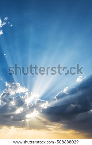 Sun beams breaking through the dark clouds at sunset. Hope, prayer, God's mercy and grace. Beautiful spectacular conceptual meditation background.
