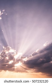 Sun beams or rays breaking through the dark clouds at sunset. Hope, prayer, God's mercy and grace. Beautiful spectacular conceptual meditation background. Artistic sunset edit.