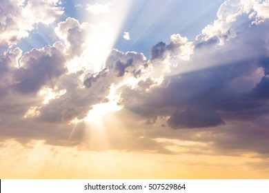 Sun beams or rays breaking through the dark clouds at sunset. Hope, prayer, God's mercy and grace. Beautiful spectacular conceptual meditation background. 