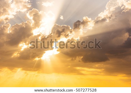 Sun beams or rays breaking through the dark clouds at sunset. Hope, prayer, God's mercy and grace. Beautiful spectacular conceptual meditation background. Artistic golden sunset edit.