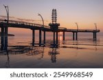 The sun beams under the dock of Brant Street Pier, as it rises over the lake during the morning at Burlington, Ontario, Canada