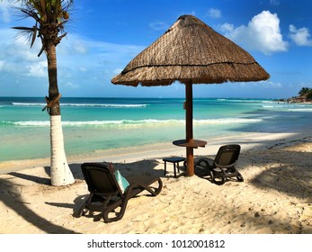 Sun beds and umbrella on the empty beach in Cancun, Mexico