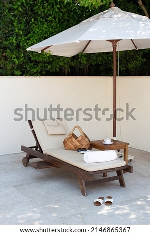 sun beds and umbrellas. Sun loungers with umbrellas by the pool. Summer concept. Sunbeds under tropical palms