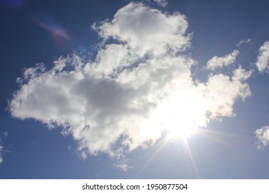 Sun behind a cloud in the blue sky