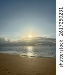sun behind clouds at the beach