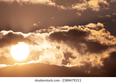 the sun behind clouds in the morning