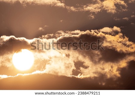 the sun behind clouds in the morning