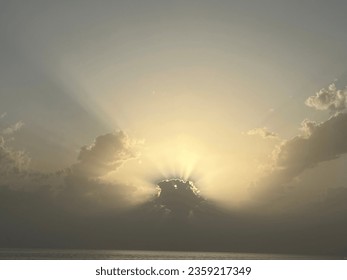 Sun behind the clouds with shadow rays