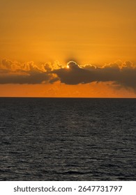 Sun behind clouds at sunset