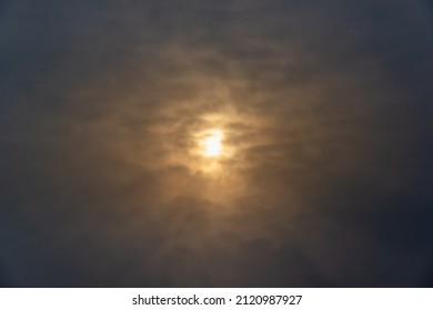 Sun Behind Dark Snowy Clouds.