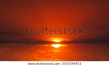 The sun is in a bloody sky with clouds. Abstract dark red sky background. Dramatic red sky. Red sunset with clouds. Fantastic sunset background with copy space for design. The end of the world.