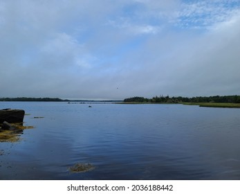 The sun breaking through the clouds over water.