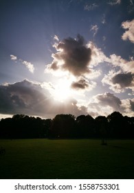 Sun breaking through the clouds in a park in Europe