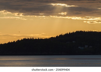 Sun breaking through the clouds, reflecting off of the water.