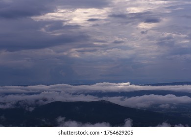 The sun is breaking through the dark clouds as the storm passes.