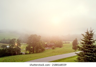 Sun Breaking Through Foggy Clouds Over A Mountain Valley