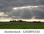 The sun breaks through the clouds over an agriculturally used area in North Rhine-Westfalia, Germany.