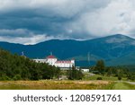 Sun breaks through rain clouds by Mount Washington behind famous hotel in the White Mountains of New Hampshire.