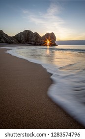 Sun Burst Sunrise Through The Arch At Durdle Door, Dorset