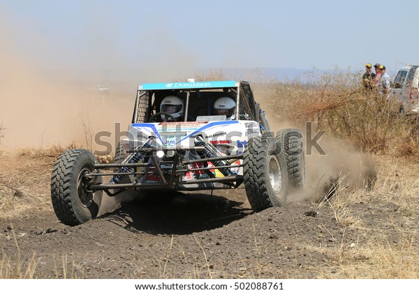 Sun City, South Africa - OCTOBER\
1, 2016: Front view of white Chenowth rally car racing through bush\
at Sun City 450 Rally Racing event, Sun City, South Africa \
