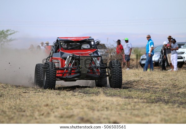 Sun City, South Africa - OCTOBER 1,\
2016: Front view of Speeding red Hellcat rally car in race at Sun\
City 450 Rally Racing event, Sun City, South Africa \
