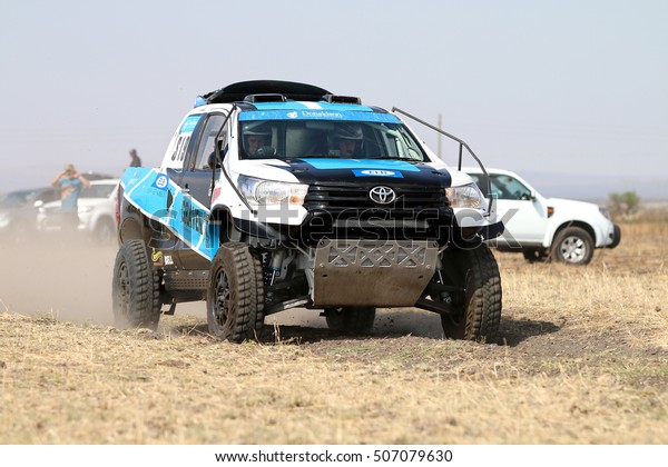 Sun\
City, South Africa - OCTOBER 1, 2016: Close-up view of Speeding\
white and blue Toyota Hilux twin cab rally car in race at Sun City\
450 Rally Racing event, Sun City, South Africa \
