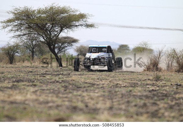 Sun City, South Africa\
Ã¢?? OCTOBER 1, 2016: Front view of white Chenowth rally car racing\
through bush at Sun City 450 Rally Racing event, Sun City, South\
Africa  