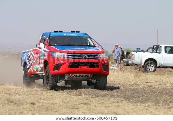 Sun City, South Africa - OCTOBER 1, 2016: Forty Five
degree close-up view of Speeding red and blue Toyota Hilux single
cab rally car in race at Sun City 450 Rally event, Sun City, South
Africa  