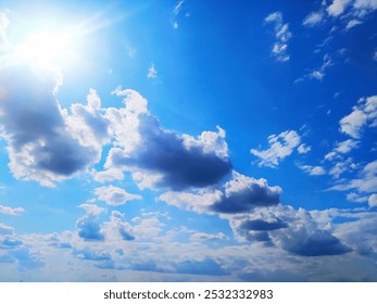 The sun and clouds in the sky. Blue sky on the background of clouds. Landscape of the sky. Blue sky with the sun and white clouds on a day of good weather blur