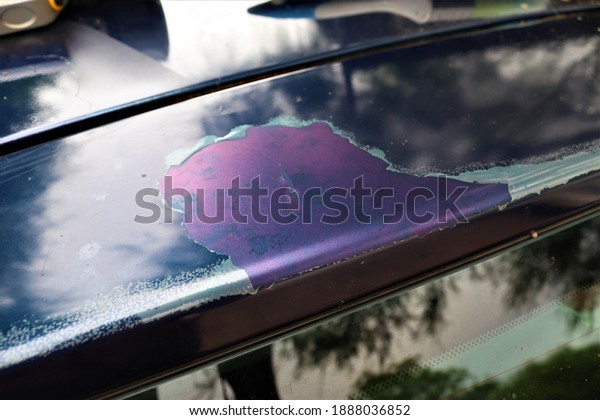 Sun\
damage seen on the roof of a vehicle .This has caused the clear\
coat of paint to peel off from the body of the\
car.