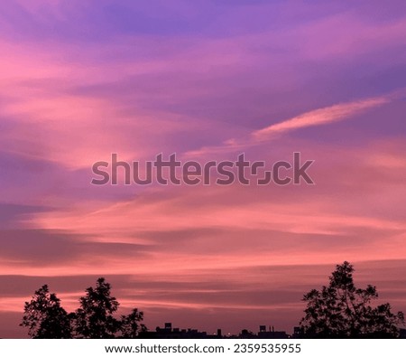 As the sun disappears completely, the sky transforms into a sea of deepening hues of orange, pink, and purple paint the heavens, illuminating the clouds that seem to be aflame.