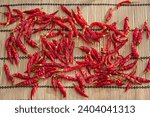 Sun dried red´ hot chilli peppers on the bamboo mat. Traditional and natural way of food preservation Dried peppers will be used in kitchen like spice and healty seasoning for asian and mexican dishes
