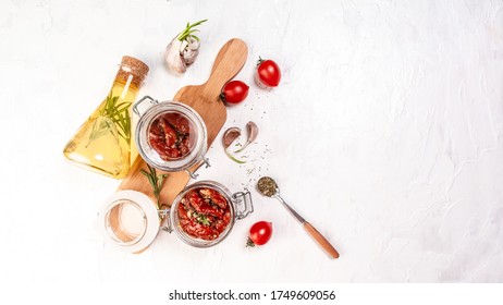 Sun dried tomatoes with fresh herbs and spices in spoon on a light table. top view. Long banner format. space for text. - Shutterstock ID 1749609056